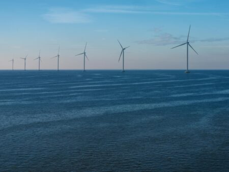 Modern wind turbines generating renewable energy in open field