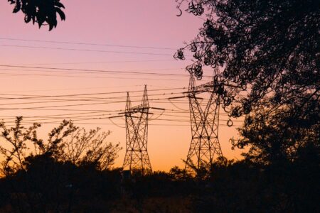 Why Financial Advisors Are Recommending Utility Stock Diversification Strategies Electrical transmission lines silhouetted against sunset sky