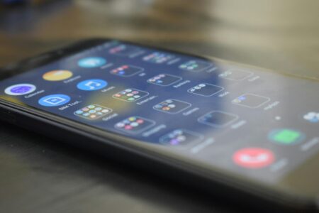 Person using mobile phone with sports betting application interface