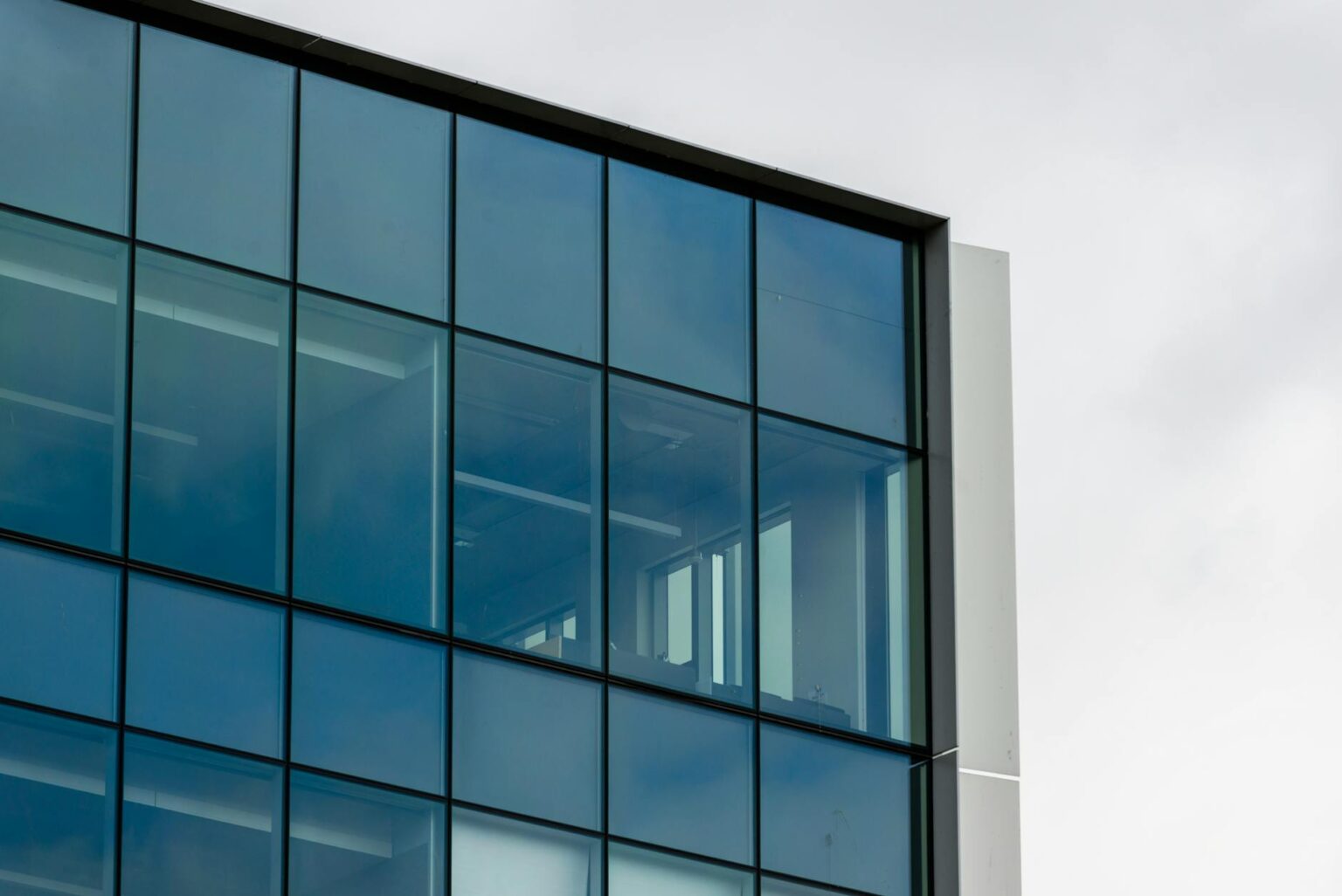 How Remote Work is Reshaping Commercial Real Estate Values Modern downtown office building with glass facade representing commercial real estate