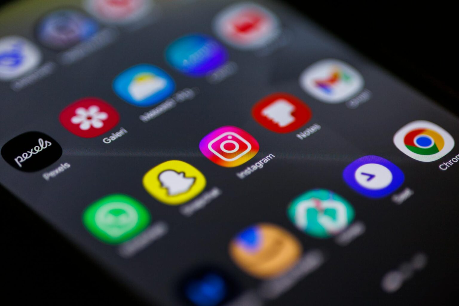 Mobile phone displaying various subscription app icons on screen