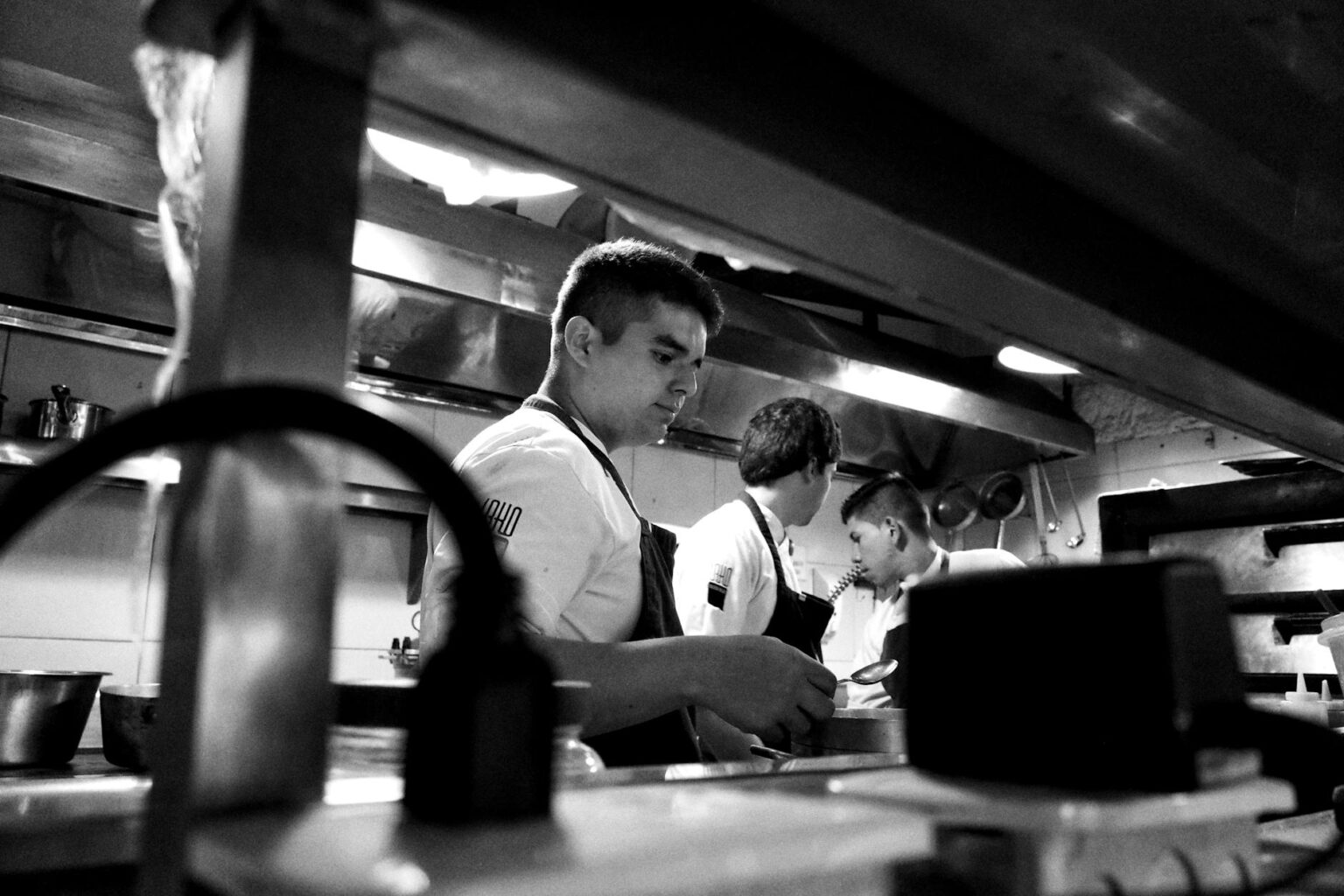 Restaurant Industry Labor Shortage Drives Widespread Menu Price Increases Restaurant kitchen workers preparing food during busy service period
