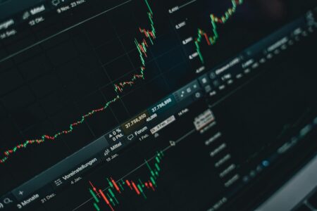 Busy financial trading floor with multiple computer screens displaying market data and currency exchange rates