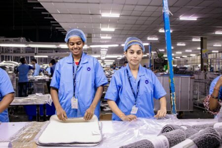 Manufacturing workers operating machinery in modern industrial facility