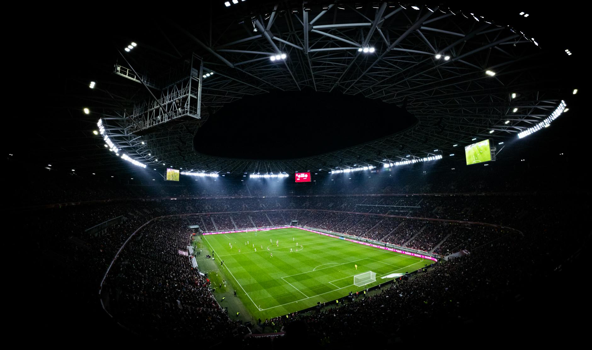 Illuminated stadium lights at sports venue during evening event