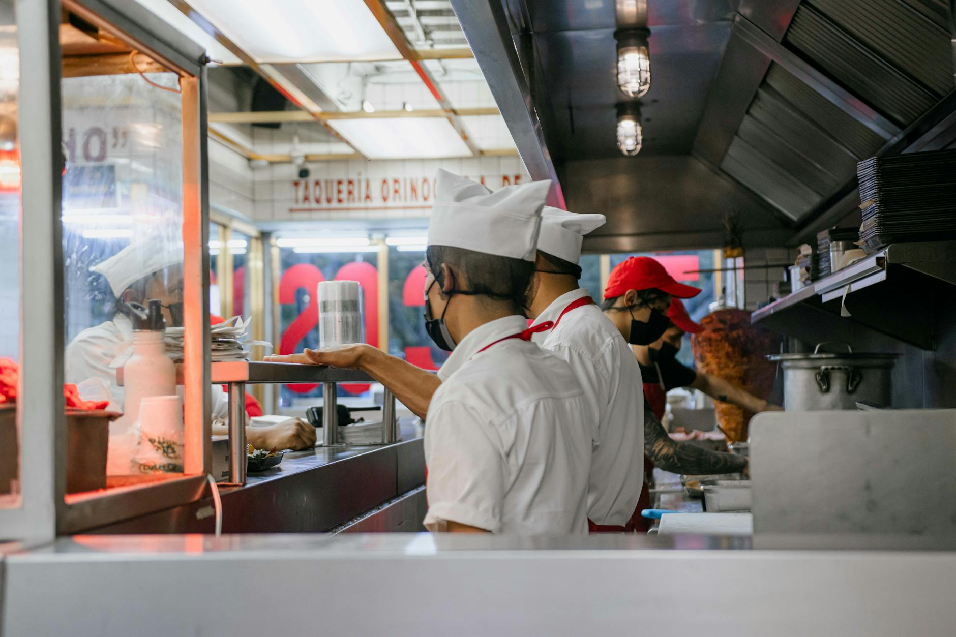 Restaurant kitchen staff preparing meals during busy lunch rush