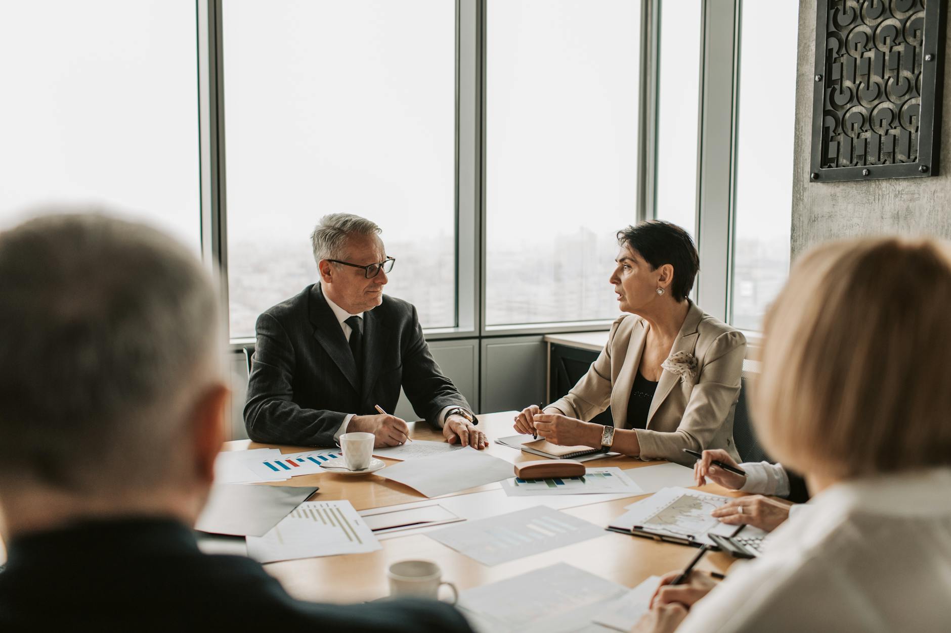 Corporate executives in boardroom discussing merger negotiations