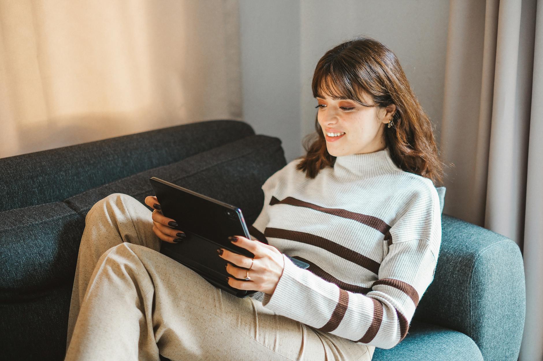Person watching streaming content on tablet device in living room