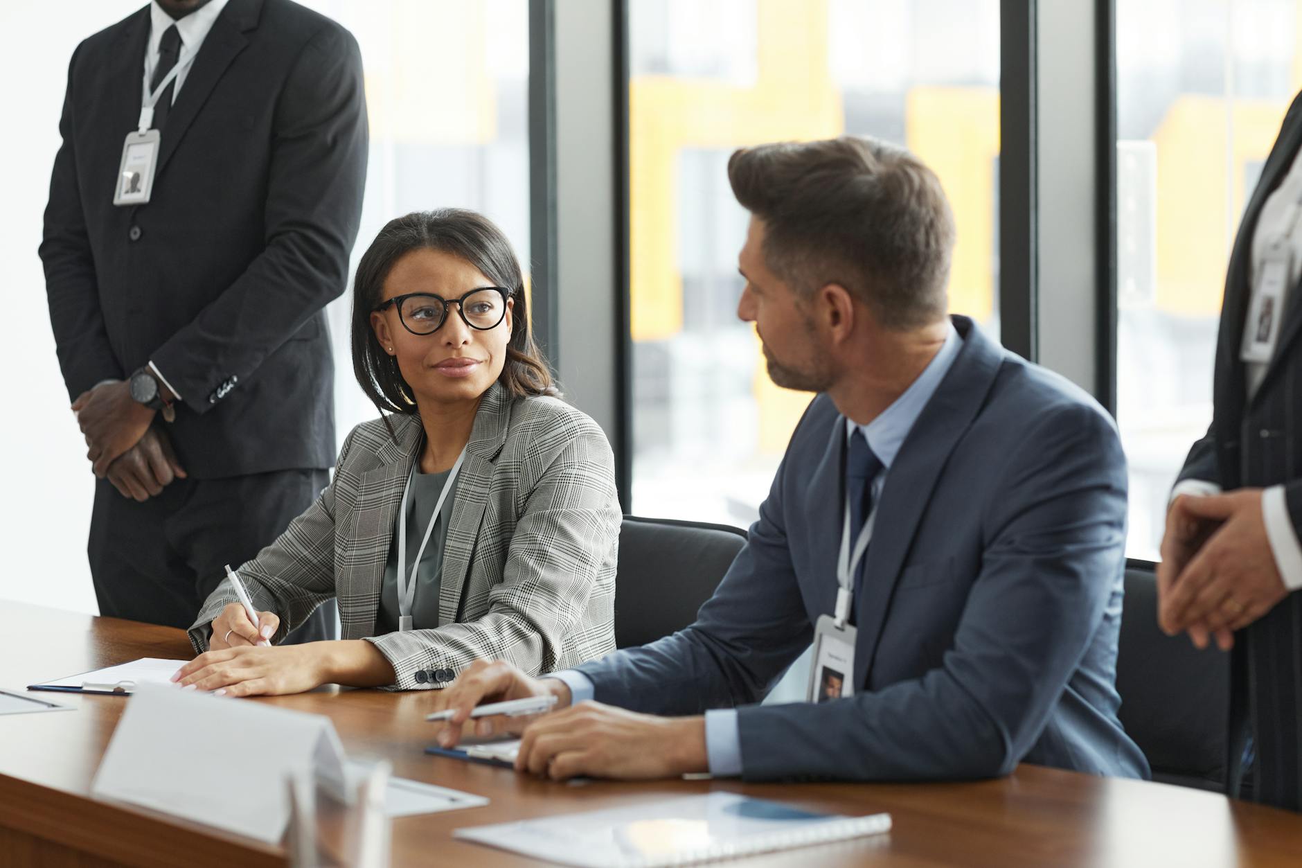 Business professionals discussing documents around conference table