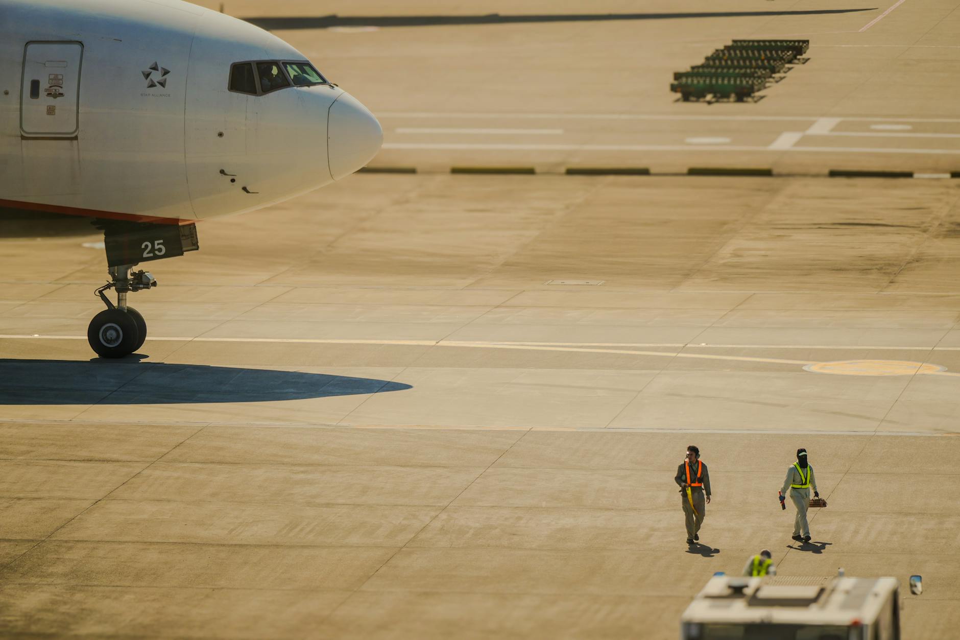 Commercial aircraft on airport runway with cargo loading equipment nearby