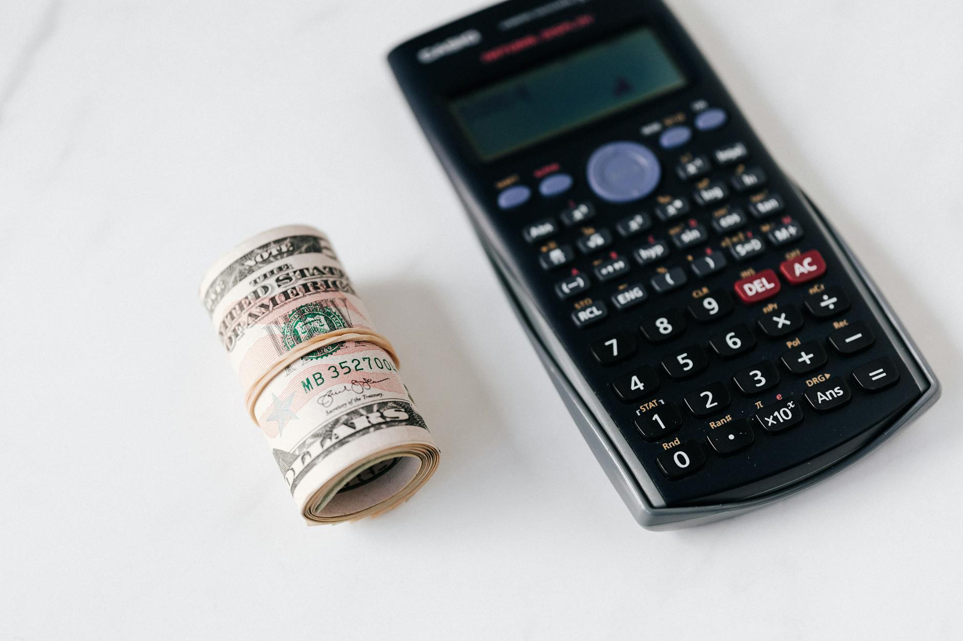 Financial calculator with cash and investment documents showing dividend income calculations and portfolio planning