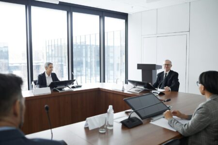 Professional business meeting with executives discussing strategy around conference table
