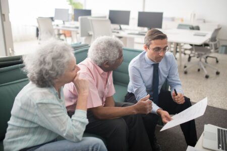 Defined Benefit Pension Plans Stage a Quiet Comeback Business professionals reviewing pension and retirement plan documents in a corporate office setting