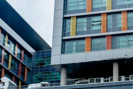 Modern office building exterior with glass windows reflecting empty floors