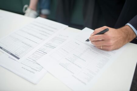 Insurance policy documents and house keys on wooden desk representing property insurance coverage decisions