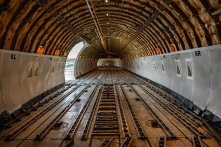 Major Airlines Convert Unused Aircraft Into Cargo-Only Operations Interior view of aircraft cargo compartment with freight containers and loading equipment