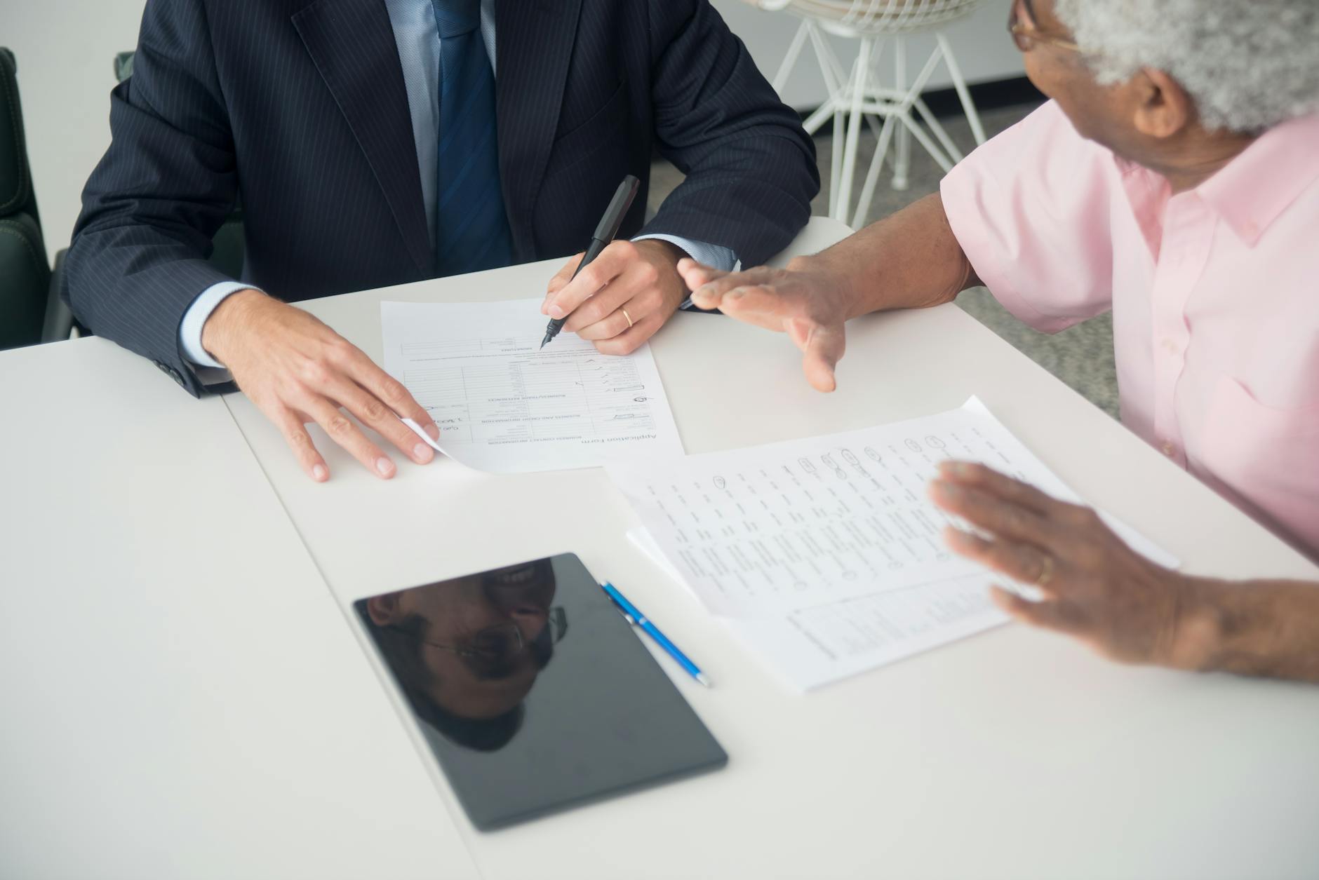 Business professional reviewing investment documents at a desk