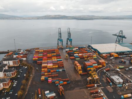 Shipping containers stacked at a busy cargo port during an import surge