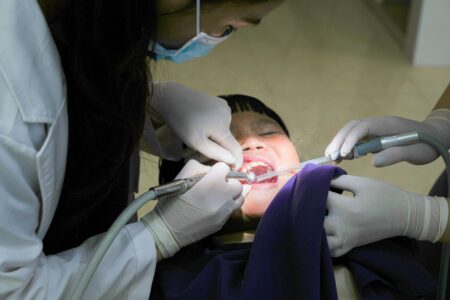 An older adult sitting in a dental chair during a checkup, representing seniors relying on Medicaid dental coverage