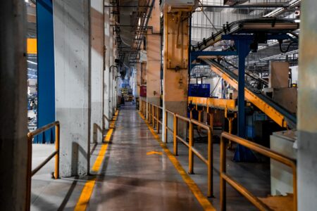 Empty manufacturing factory floor with idle machinery during investment pause
