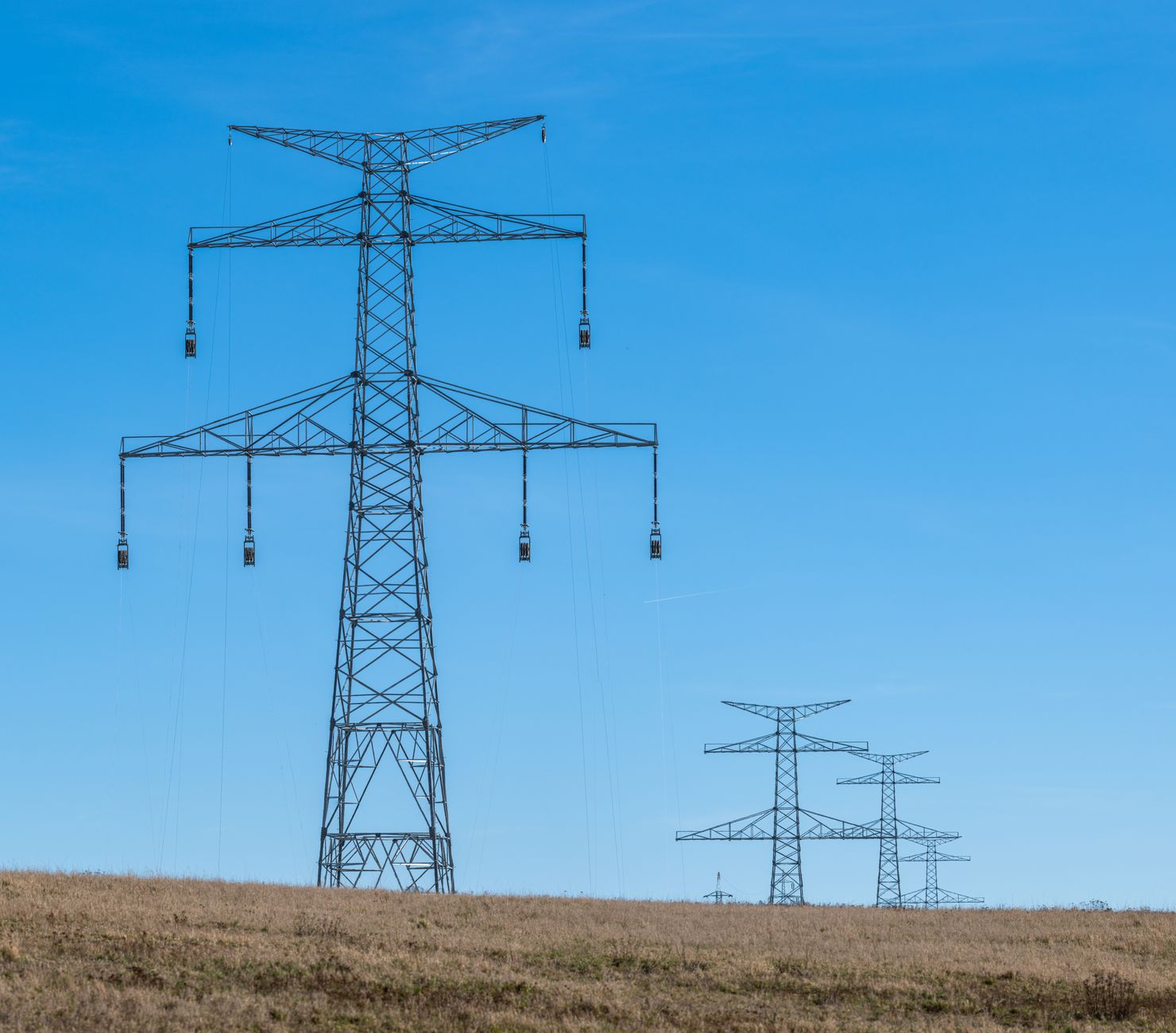 High-voltage electric transmission towers and power lines at dusk