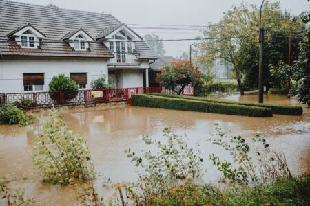 Flooded residential street with water covering road and driveways