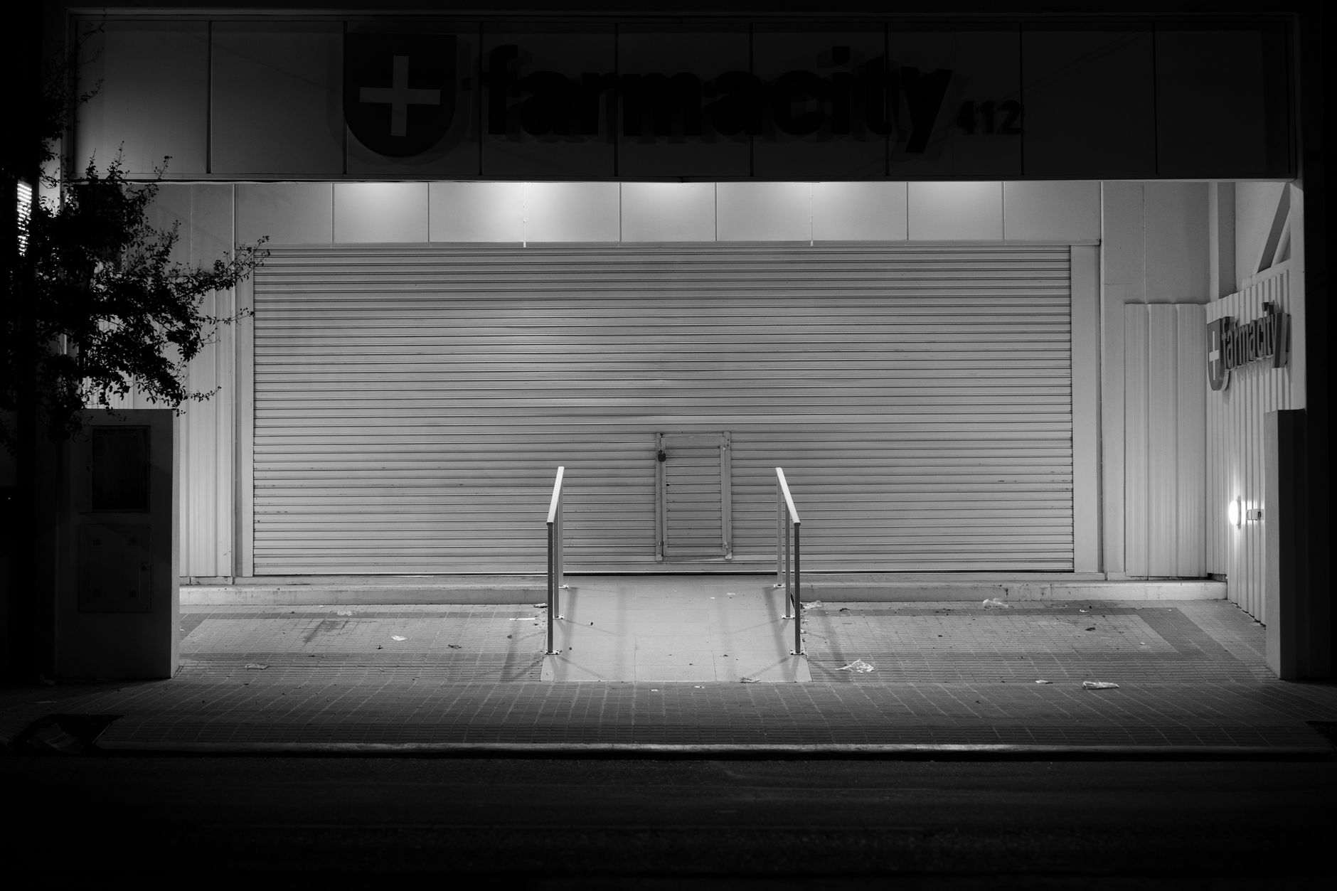 Empty retail pharmacy storefront with closed signs in a low-income neighborhood