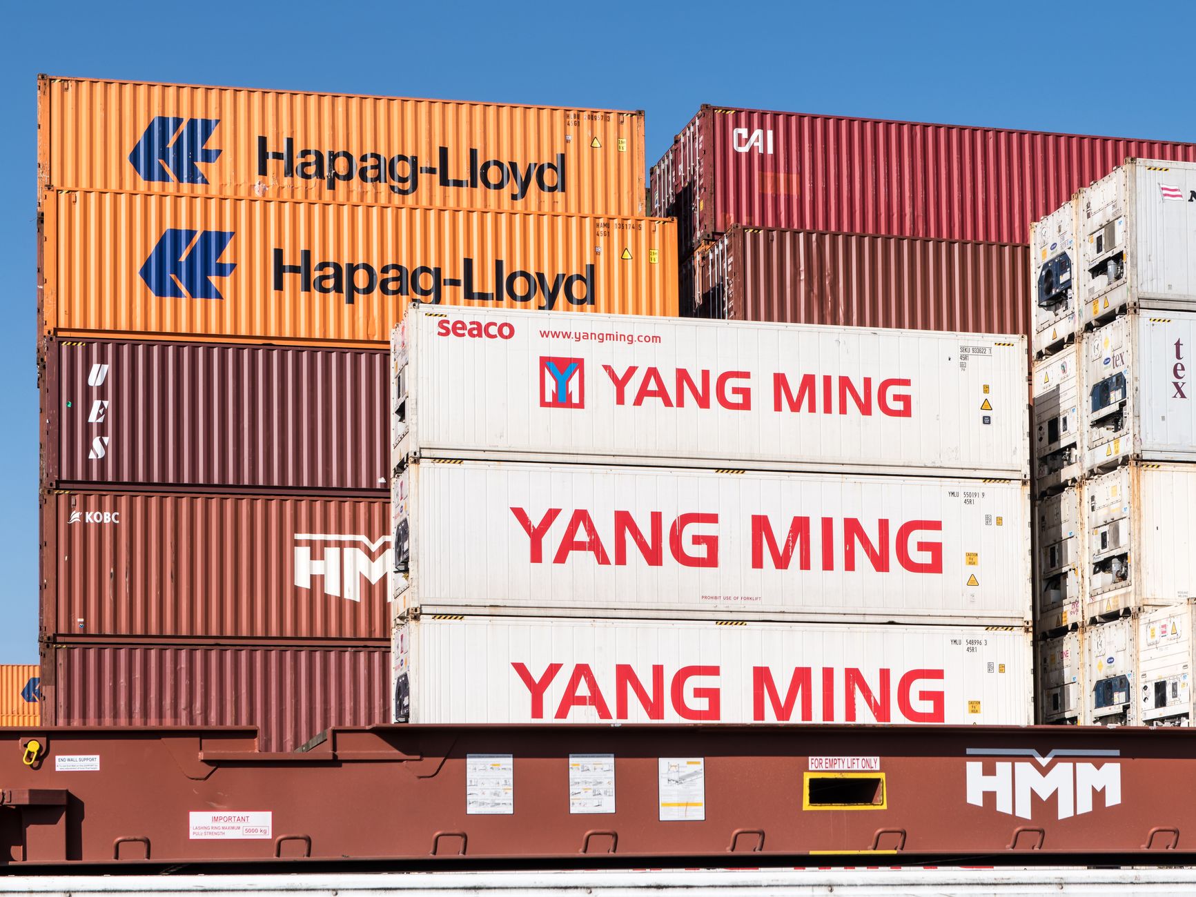 Rows of shipping containers stacked at a commercial port terminal