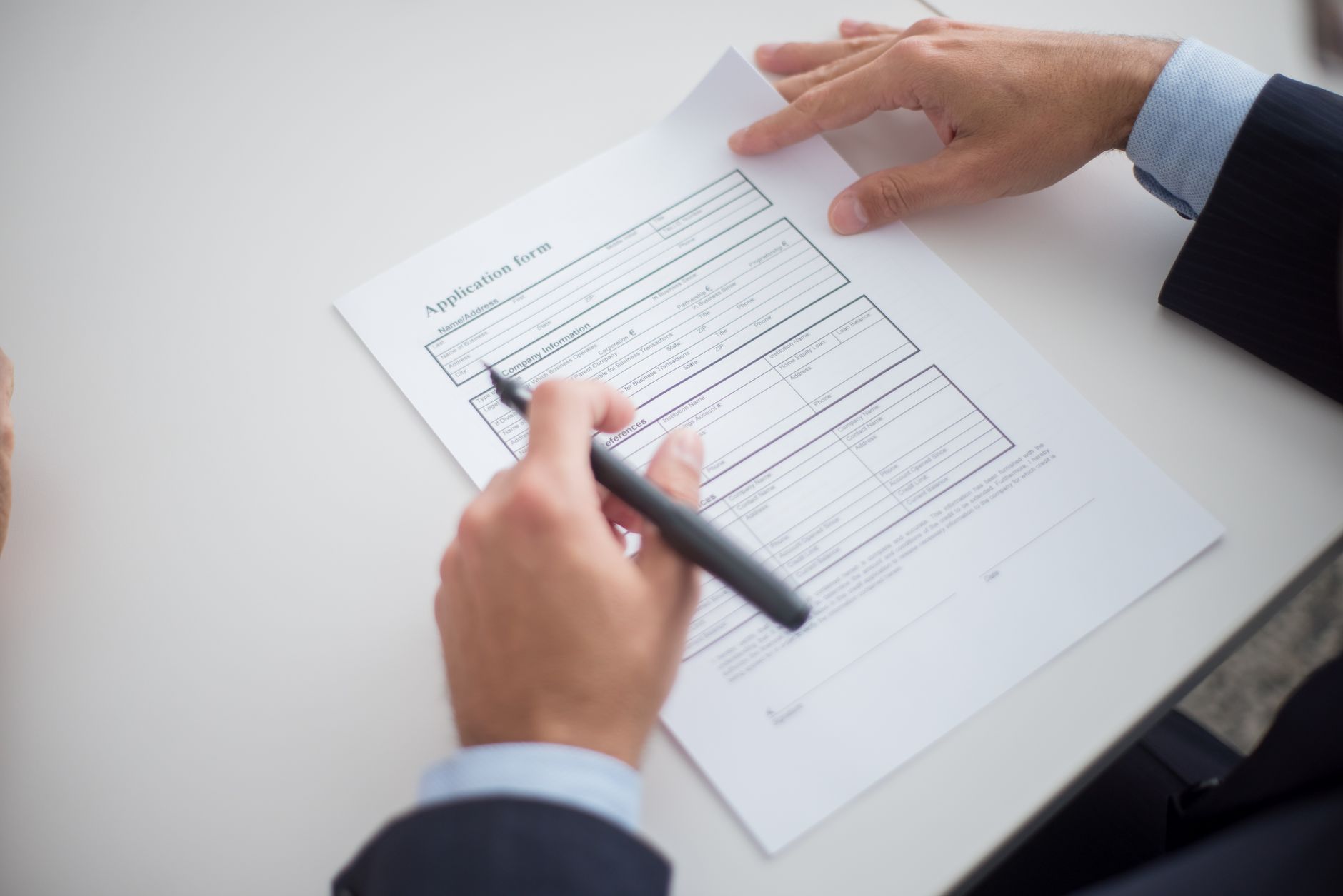 Housing application paperwork on a desk representing the administrative burden of federal housing assistance programs