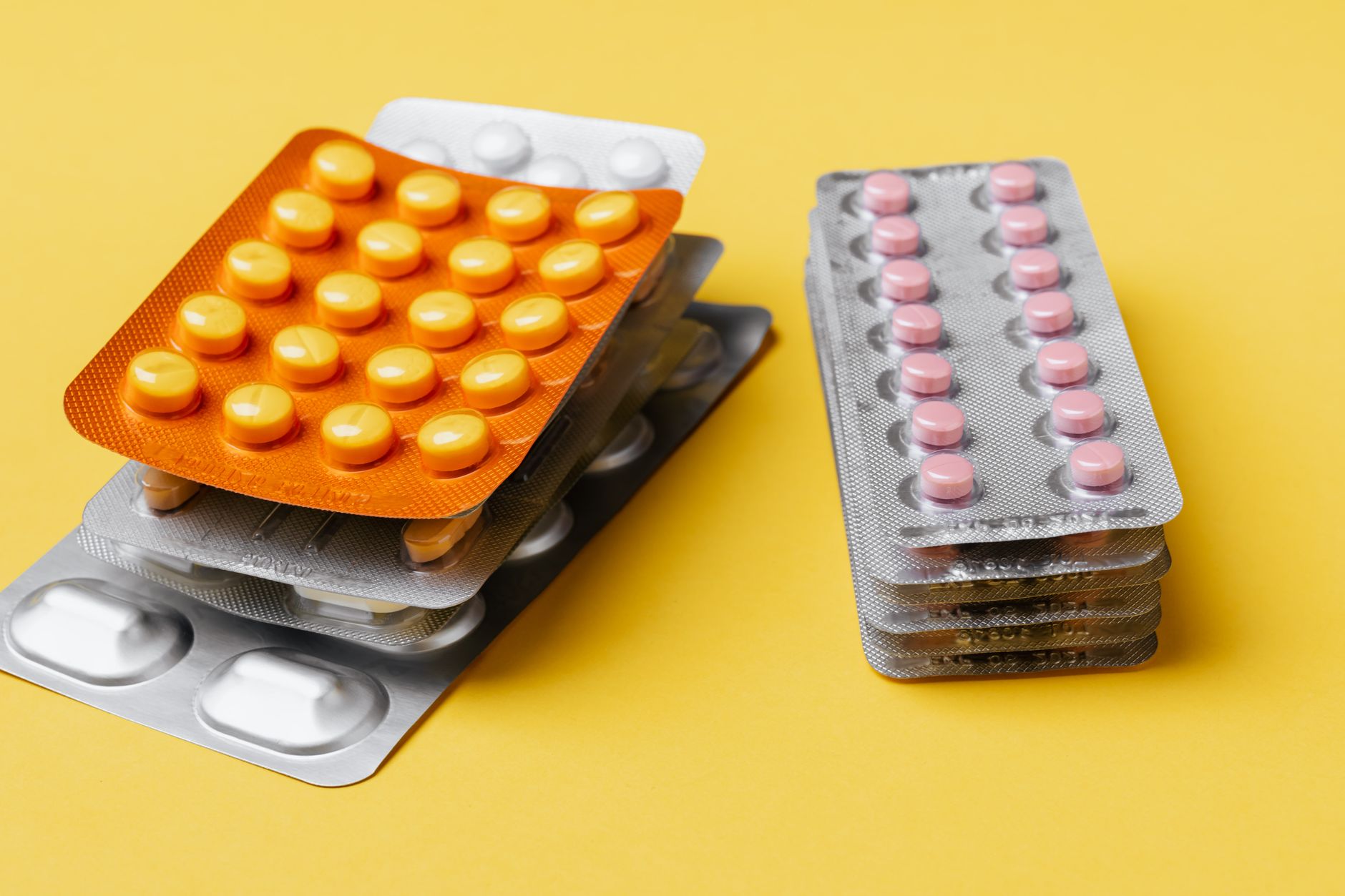 Prescription pill bottles on a pharmacy counter representing medication access challenges