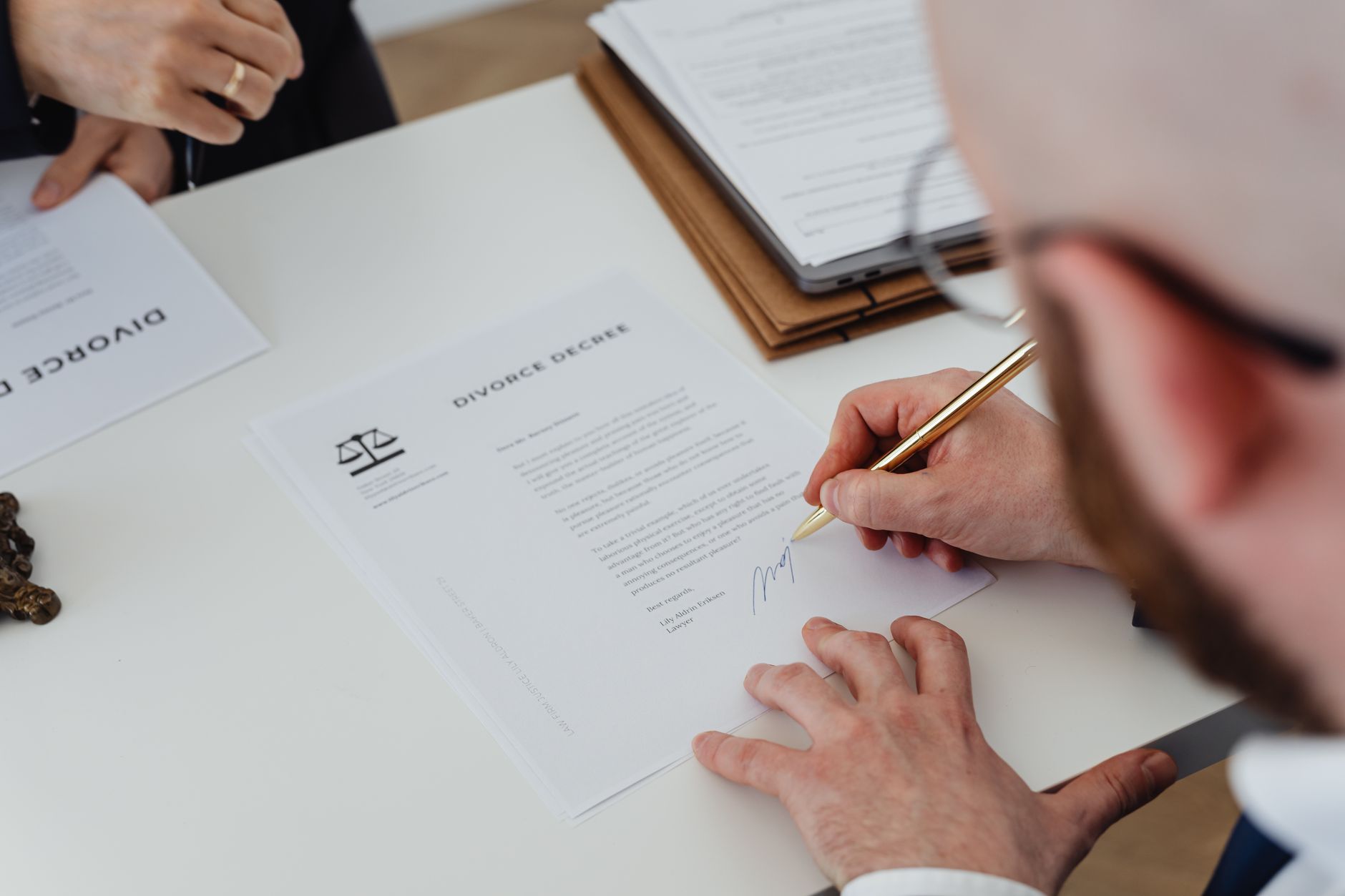 Two people reviewing and signing a contract at a desk representing a rent-to-own housing agreement