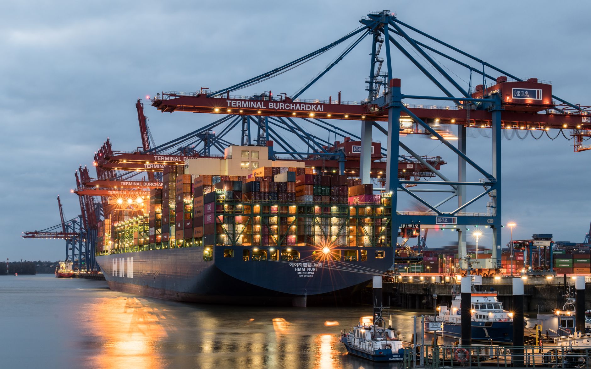 Cargo shipping containers stacked at a port representing apparel import supply chain