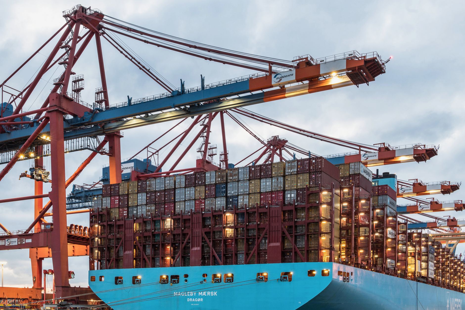 Stacked shipping containers at a busy commercial dock facility