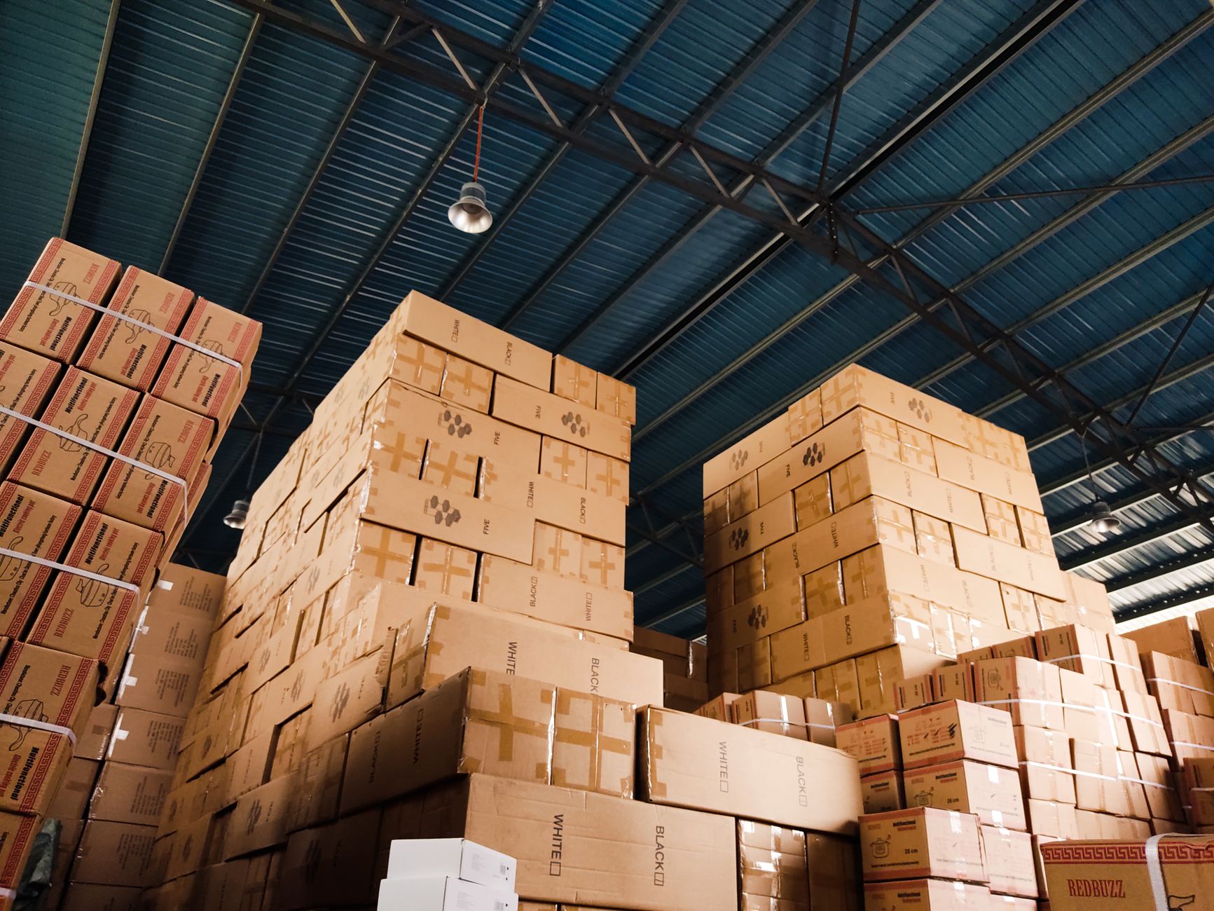 Interior of a warehouse with shelving units and stacked product boxes