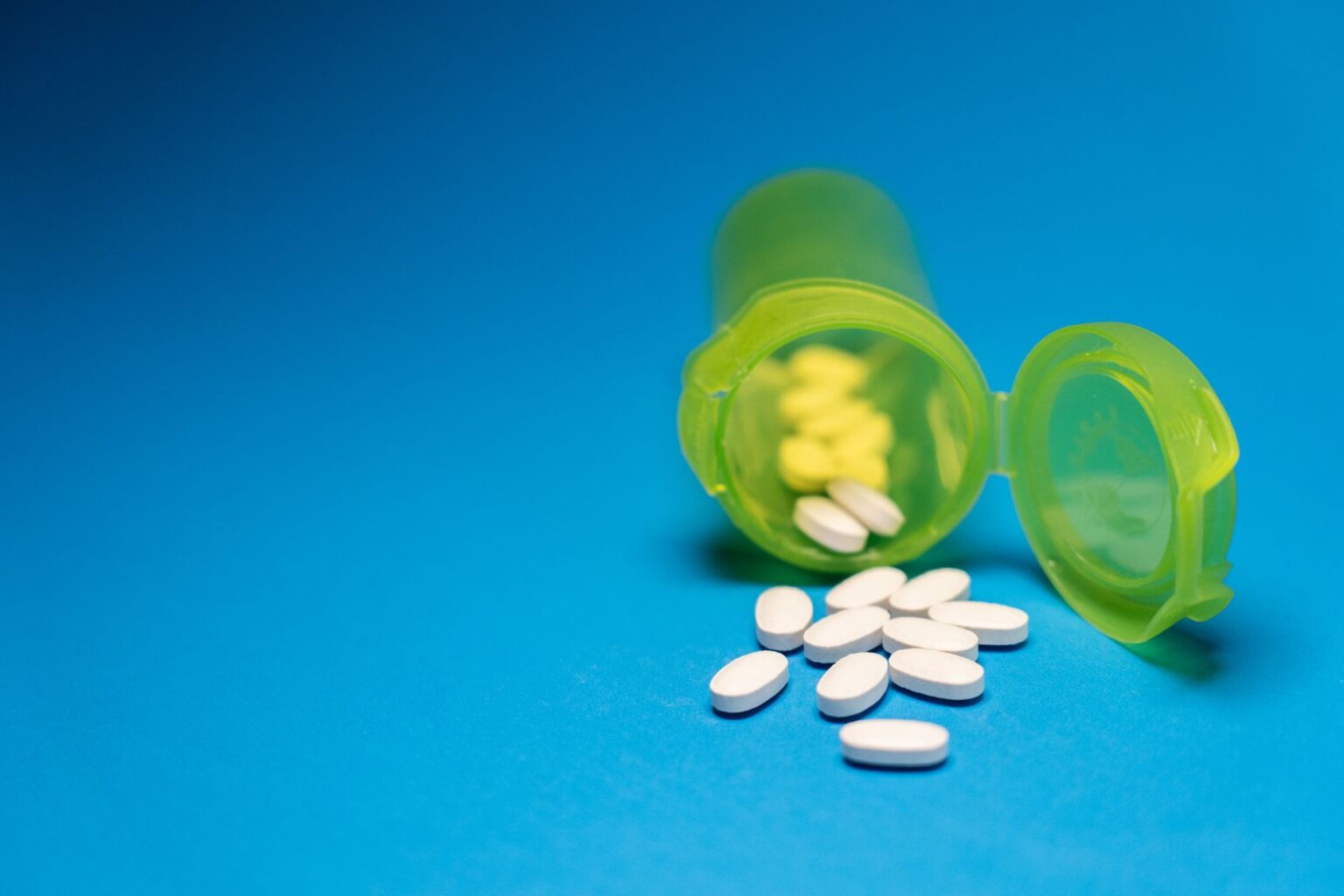 Prescription Drug Copay Accumulator Programs Drain Patient Assistance Budgets Prescription medication bottles on a pharmacy counter representing drug cost burden