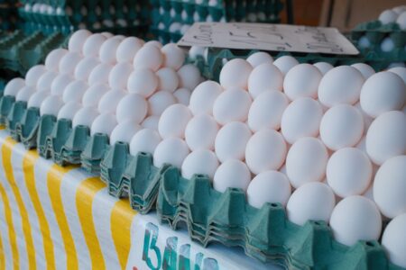 Egg Price Volatility Rattles Food Service Operators Nationwide Cartons of fresh eggs stacked in a commercial grocery or food service setting