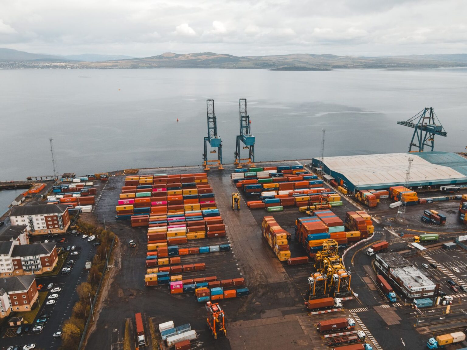 Dock Worker Contract Disputes Stall Port Automation Rollouts Large shipping containers stacked at a busy commercial seaport