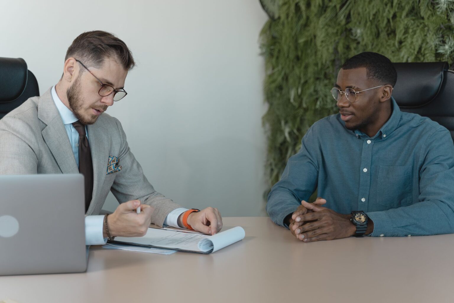 Visa Sponsorship Freezes Quietly Reshape High-Skill Hiring Markets Two professionals meeting across a desk during a job interview in a modern office setting