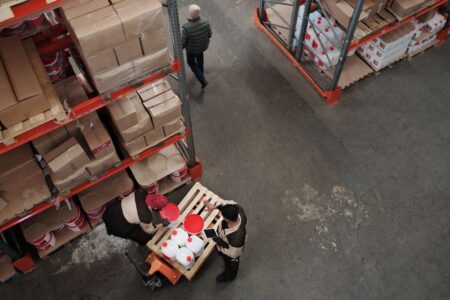 Tariff-Driven Reshoring Bets Collide With Weak Domestic Demand Workers on a domestic manufacturing factory floor during production shift