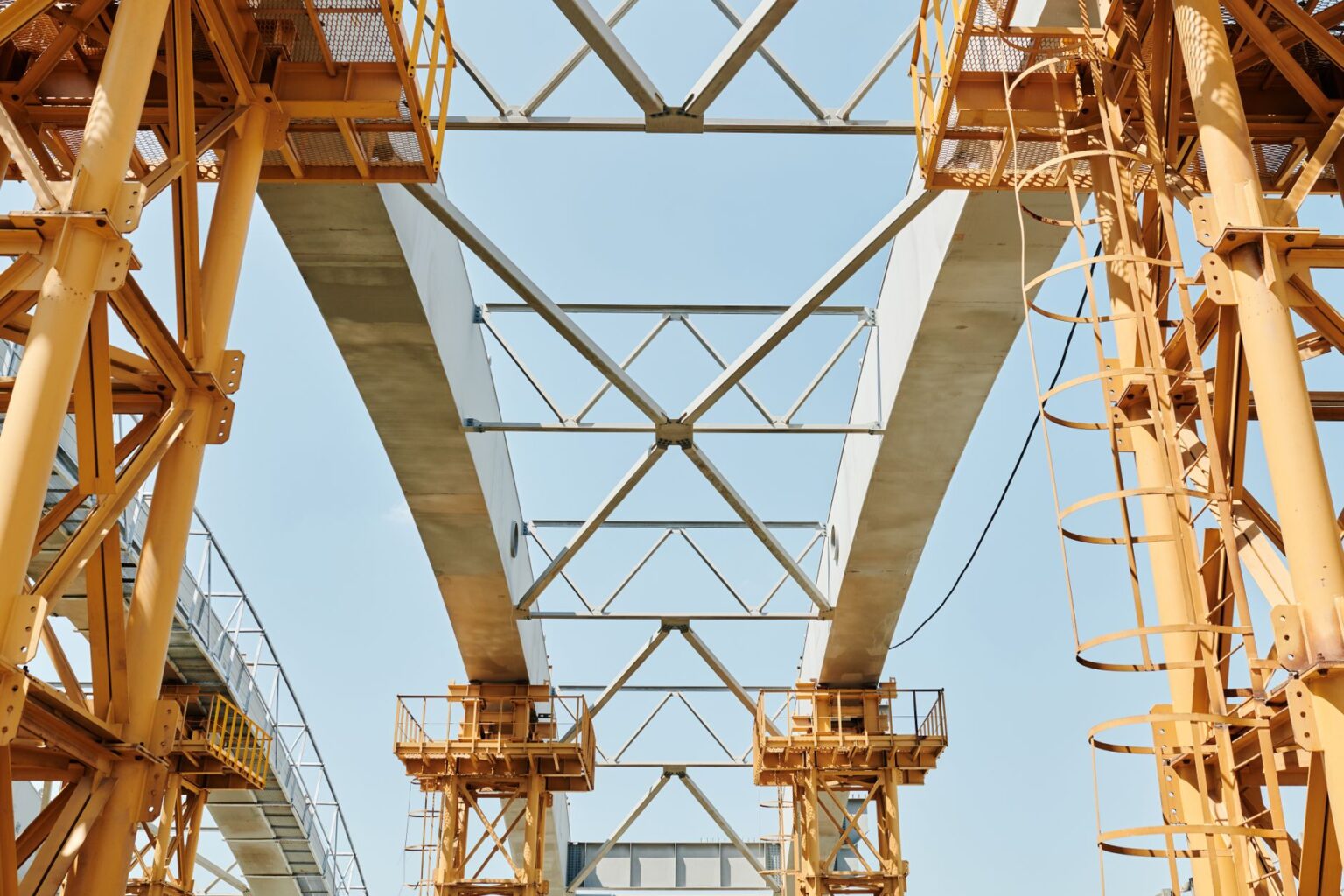 Private Credit Funds Flood Into Infrastructure as Bank Lending Retreats Large infrastructure construction site with cranes and steel framework against a clear sky