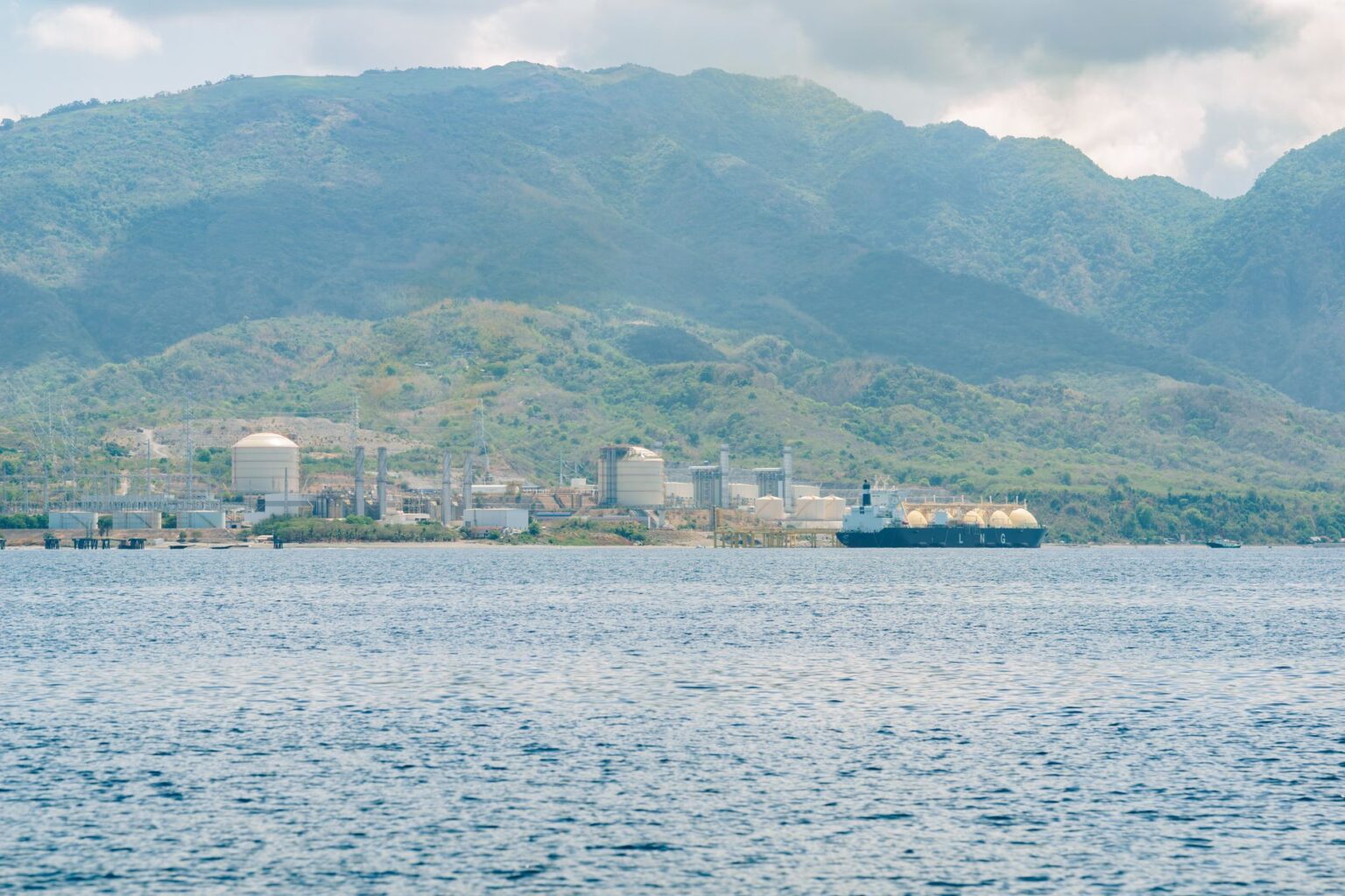 Liquefied natural gas export terminal along a coastal waterway at dusk