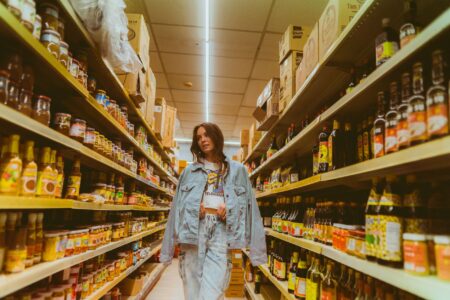 Grocery Shrinkflation Complaints Prompt FTC Labeling Scrutiny Consumer browsing product shelves in a grocery store aisle