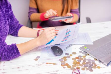 Employer Health Plan Cost Surge Squeezes Mid-Size Business Budgets Business team reviewing budget documents in a conference room