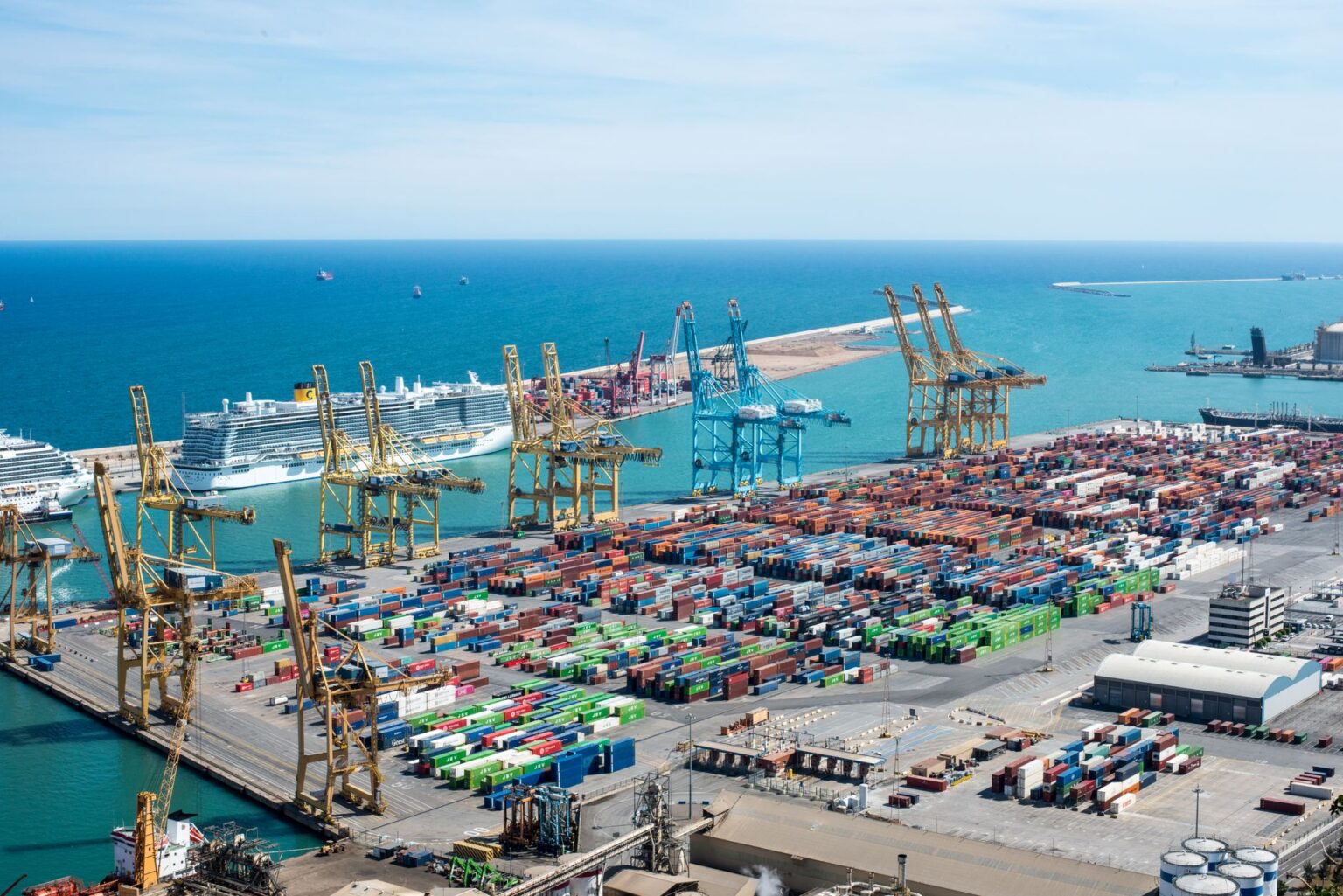 Aerial view of a small regional cargo port with shipping containers and cranes
