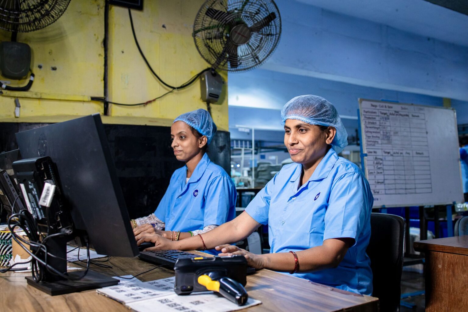 Workers on a small manufacturing factory floor operating industrial equipment