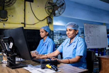 Workers on a small manufacturing factory floor operating industrial equipment