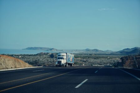 Trucking Spot Rate Collapse Deepens Carrier Cash Flow Crisis A semi-truck driving on a highway representing the trucking freight industry