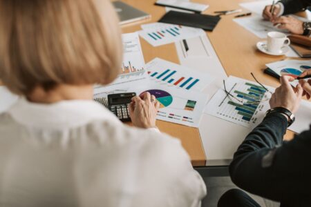 Government officials reviewing pension fund financial documents at a conference table