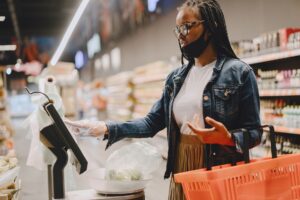 Shopper scanning loyalty card at grocery store checkout counter