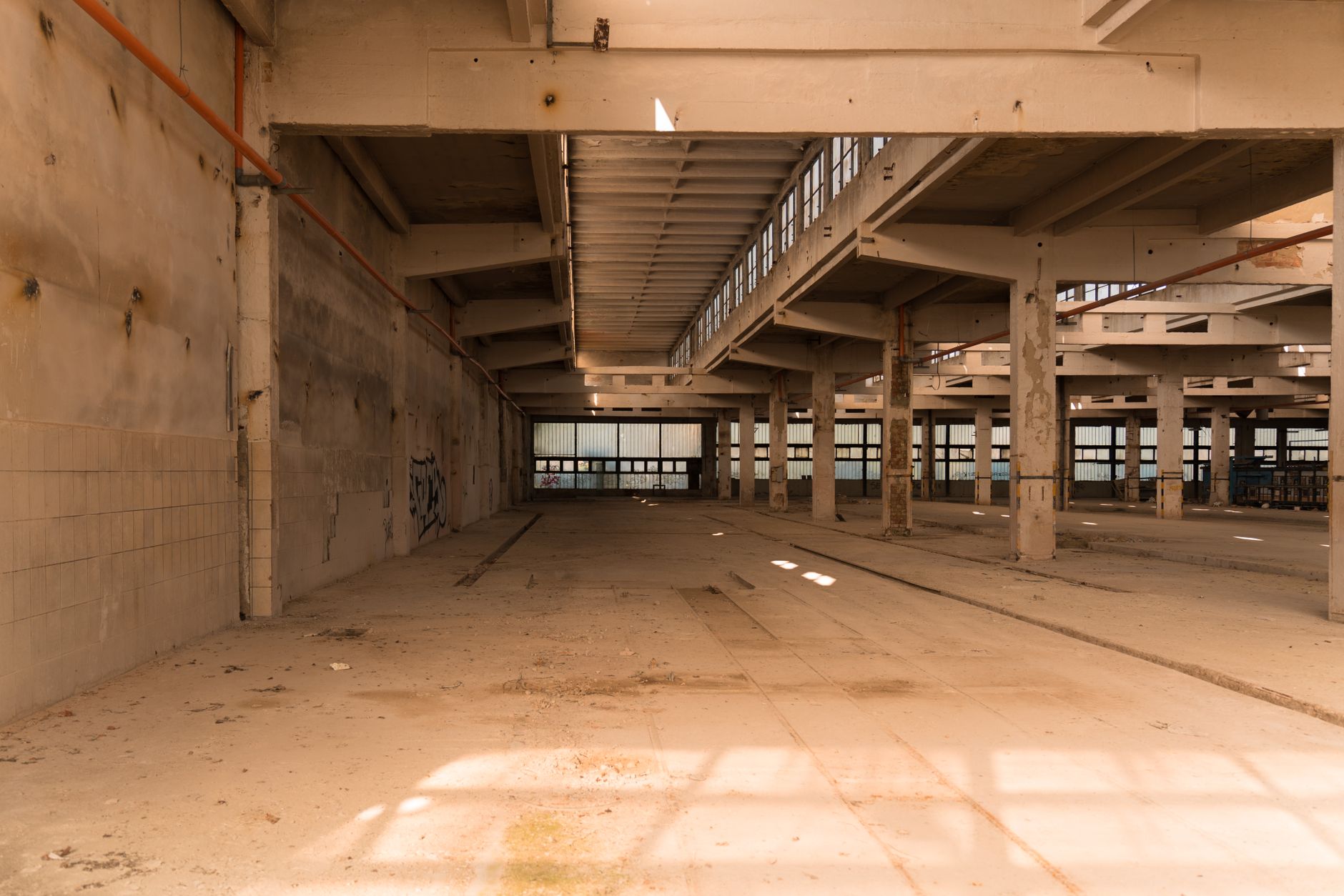 Empty industrial warehouse interior with idle machinery and no workers